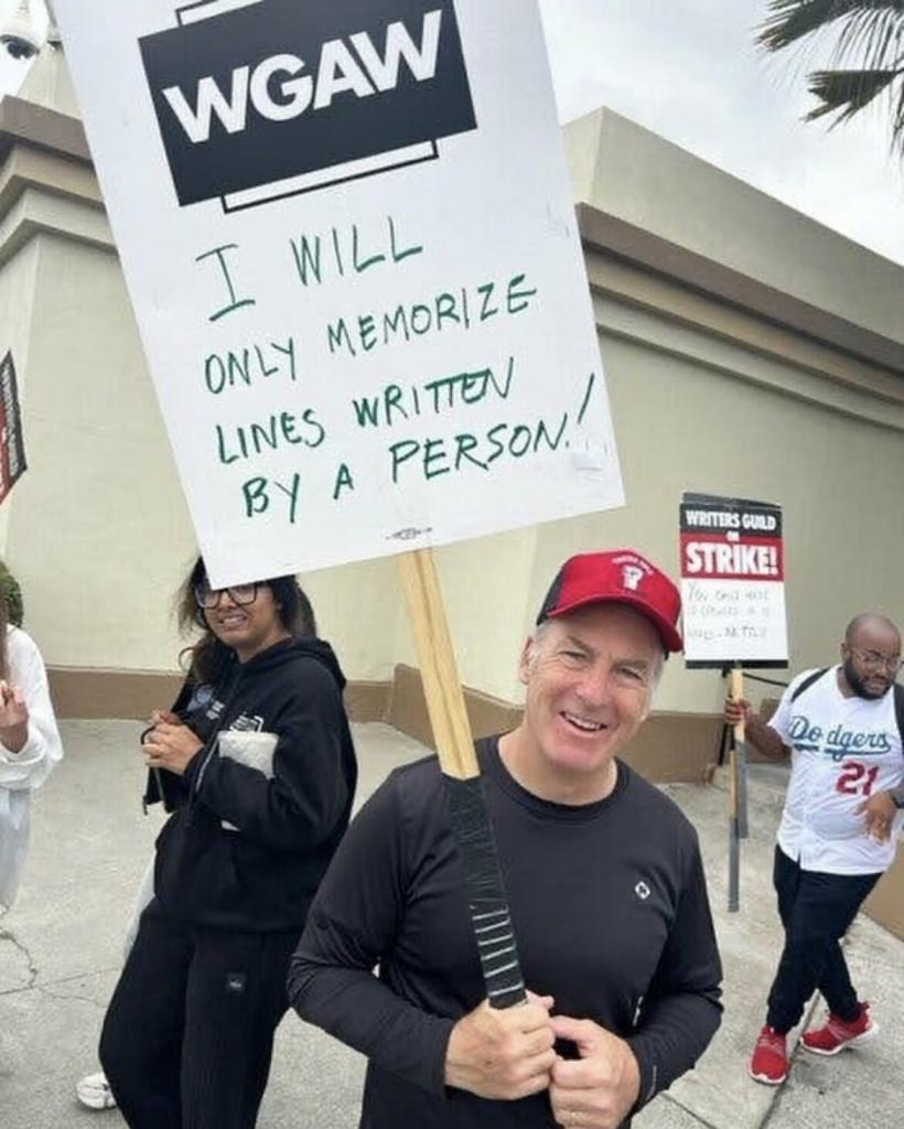 Bon Odenkirk holding up a sign: 
“I will only memorize lines written by a person”