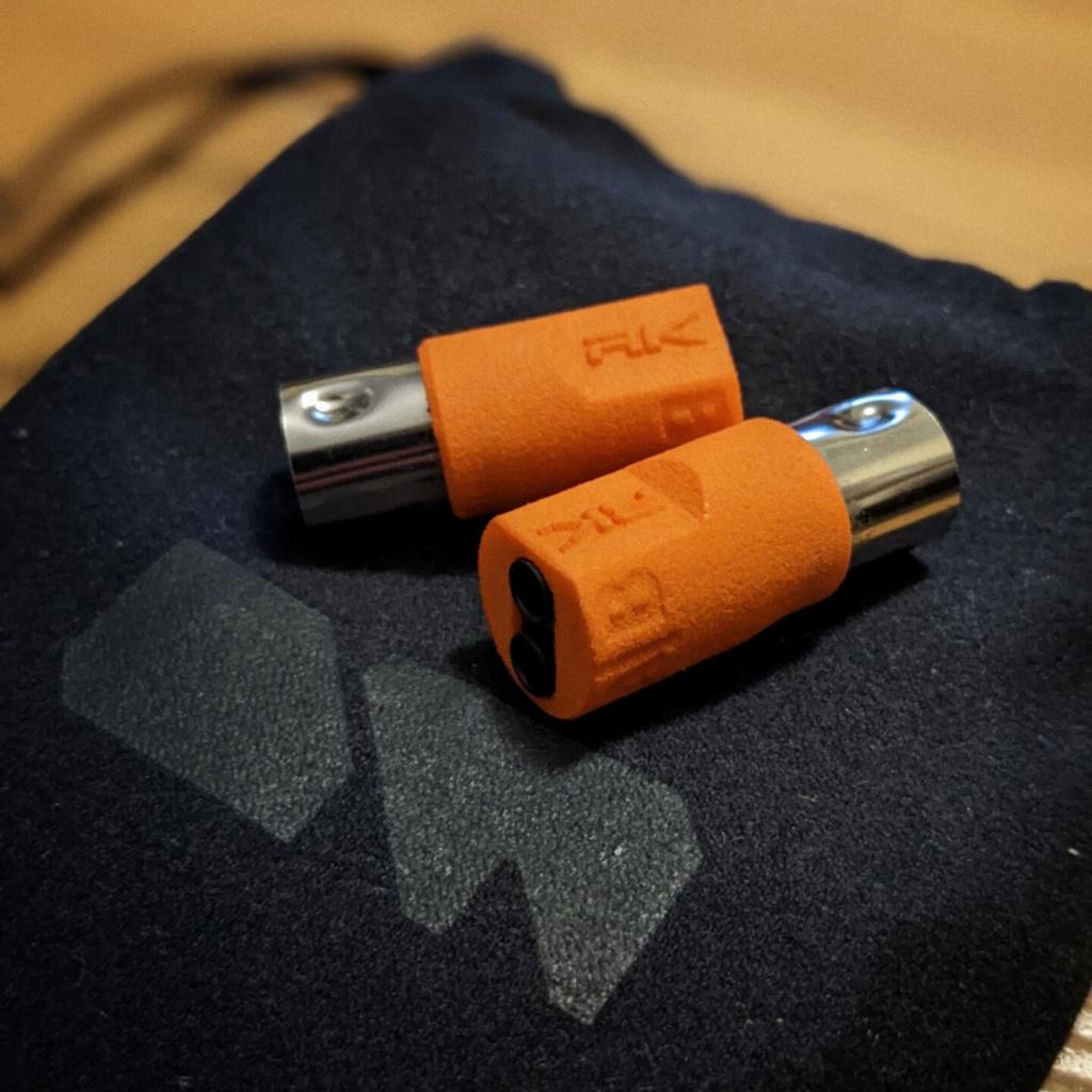 Two MIDI TRS-to-DIN adapters sitting on a M8 bag. 