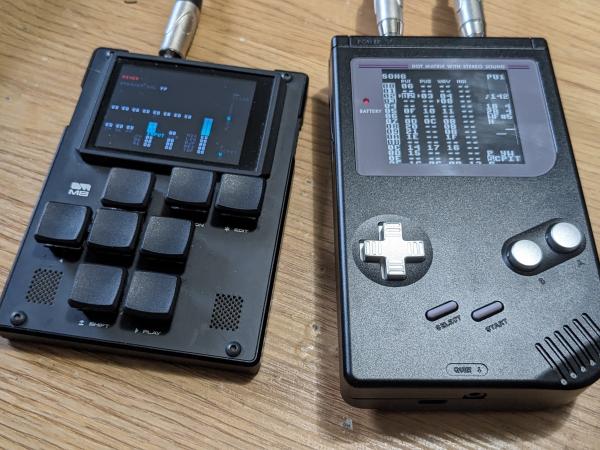 An M8 Tracker sitting next to a black anodized aluminum Game Boy with aluminum buttons.