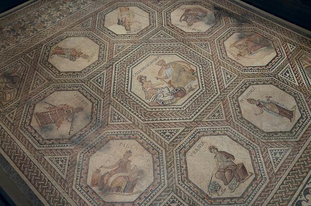 "The Vichten mosaic depicting the mythological and literary theme of the nine Muses with Calliope, the Muse of epic and elegiac poetry together with Homer in the large central medallion, around 240 AD, National Museum of History and Art, Luxembourg."

Carole Raddato / Following Hadrian, CC BY-SA 2.0, via Flickr