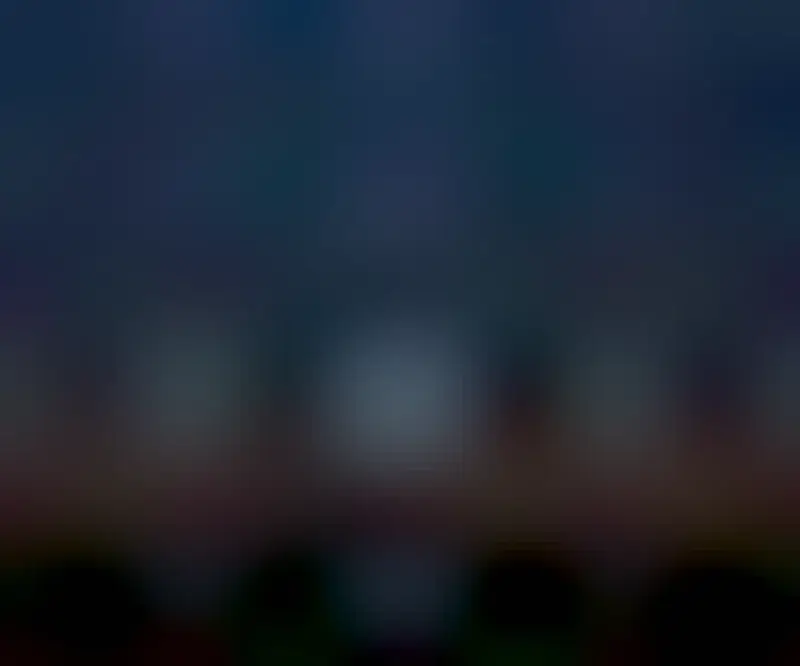 Two bright spots are seen on either side of a person standing on a hill who appears to be holding one or both of them. A starry sky appears in the background.