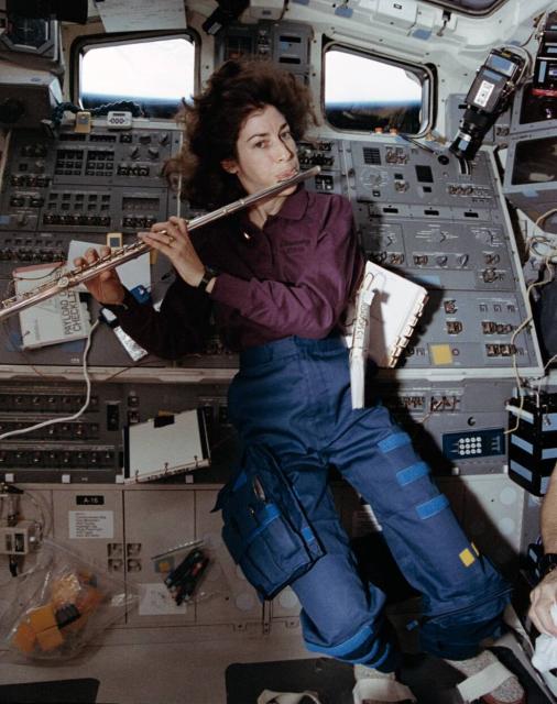 Ellen Ochoa, the first Hispanic woman in space, enjoys playing the flute in her spare time during the STS-56 mission. Credit: NASA