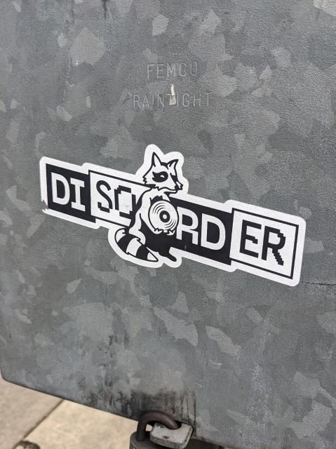 Sticker that says "Disorder" with a raccoon holding a megaphone in the middle