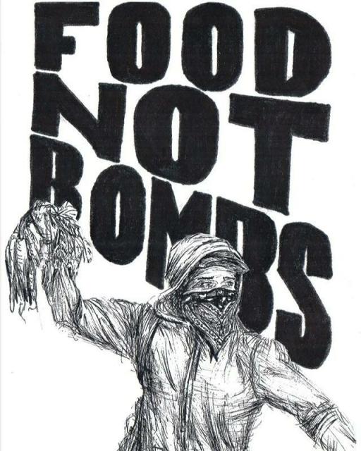 Anarchist in bloc holding a bunch of carrots, with the words Food Not Bombs in the background