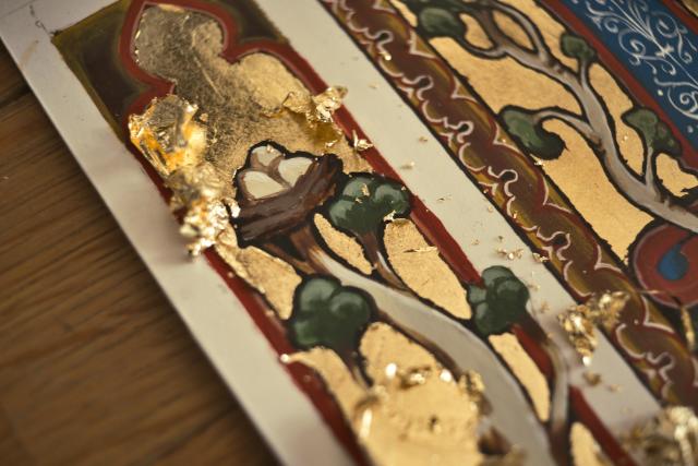 close up of a medieval illustration with gold leaf being applied, so shiny!