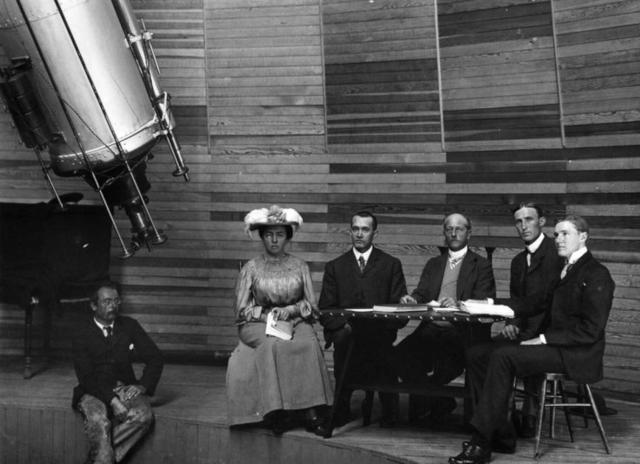 "Lowell staff at the Clark Telescope in 1905. Seated left to right: Harry Hussey, Wrexie Leonard, V.M. Slipher, Percival Lowell, Carl Lampland, and John C. Duncan."

Lowell Observatory, Public domain, via Wikimedia Commons. Color edits.