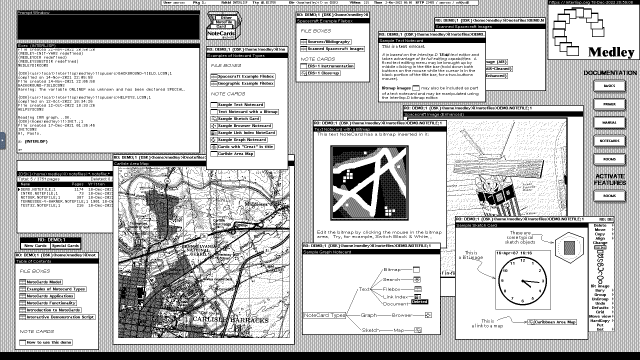 Screenshot of the black and white desktop of a 1980s graphical workstation environment. The desktop has a gray background pattern and several windows with a white background and a title bar with white text on a black background. The windows display text, bitmaps, graphs, icons, sketches, and other graphical elements.
