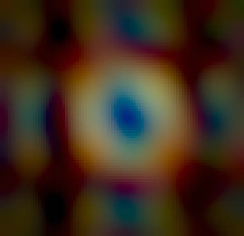 A colorful oval nebula is shown star field is shown in a sparse starfield. Fainter red nebulosity surrounds the bright oval. A relatively bright star is seen in the oval's center.