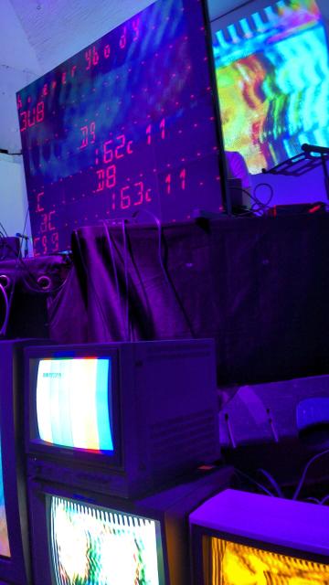 A close up of the stage featuring the display with orca code on it.
The letters are red and somehow even brighter than the TVs