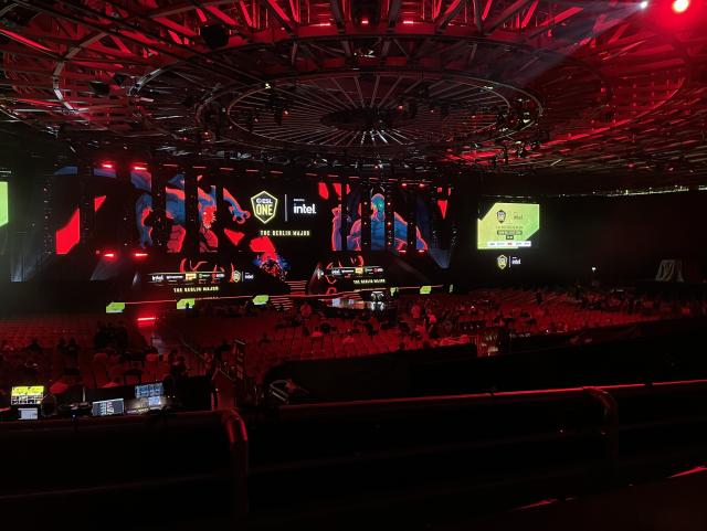 An arena full of seats and large screens in front