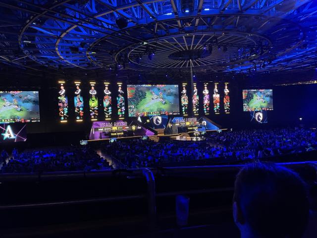 There are 3 large screens showing the game and 5 narrow screens on each side of the stage showing each player’s hero, level and inventory