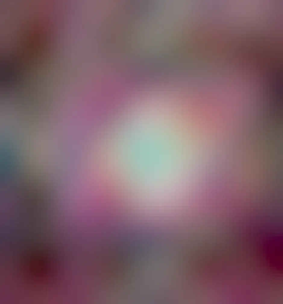 A colorful circular nebula is shown that is beige in the center, red further out, and gas violet rings even further out.