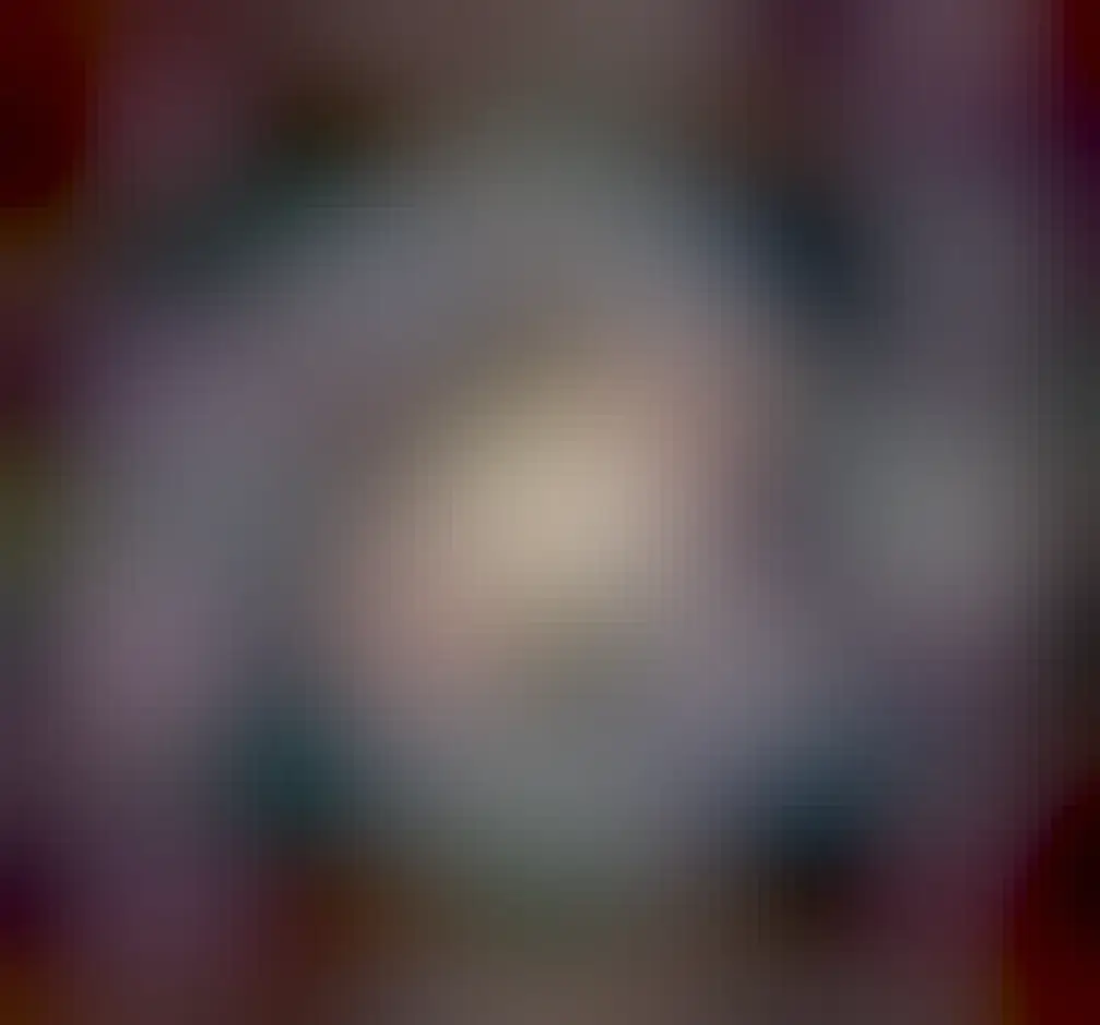 A majestic spiral galaxy is shown with spirals of bright blue stars, bright red nebulae, and dark dust.