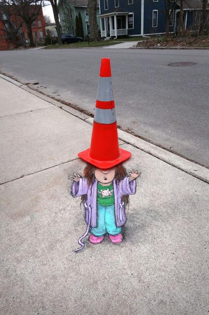 Chalk art of a child with a traffic cone as a hat by David Zinn.