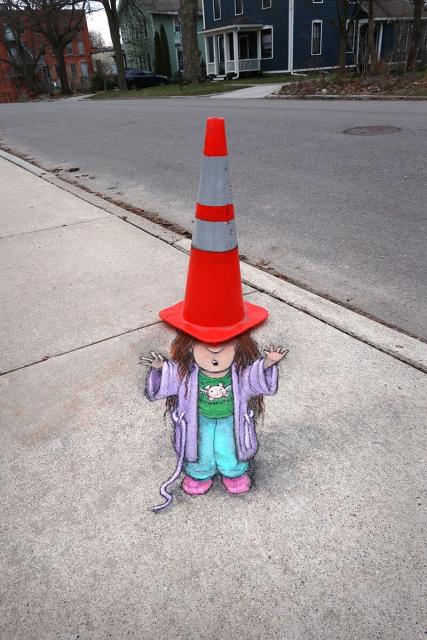 Chalk art of a child with a traffic cone as a hat by David Zinn.