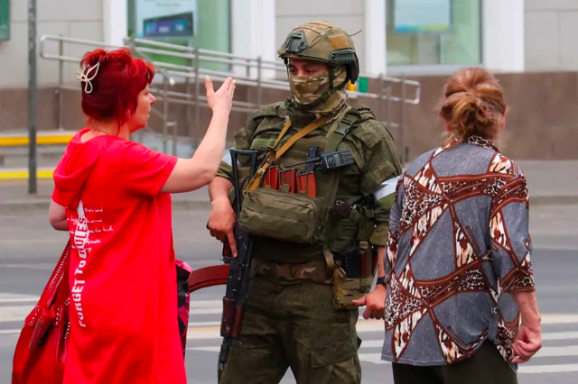 Civilians remonstrate with a soldier in the streets of Russia.