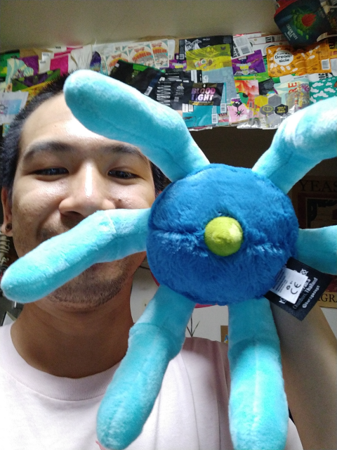 The phage plushie from below. Tail fibres emerge from the baseplate and there is a little pointy terminus to the needle poking out.