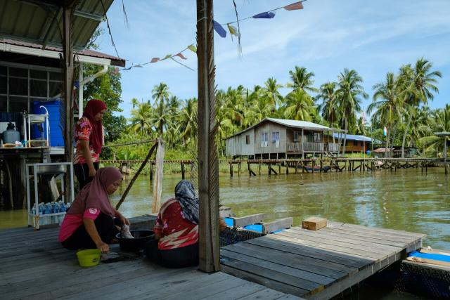 Three Suluk women prepare lunch by the river at Mumiang village.