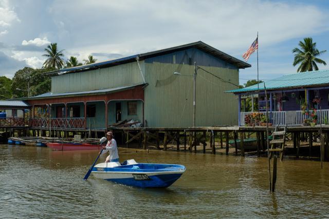 A fisherman in Mumiang village prepares to head out to sea.