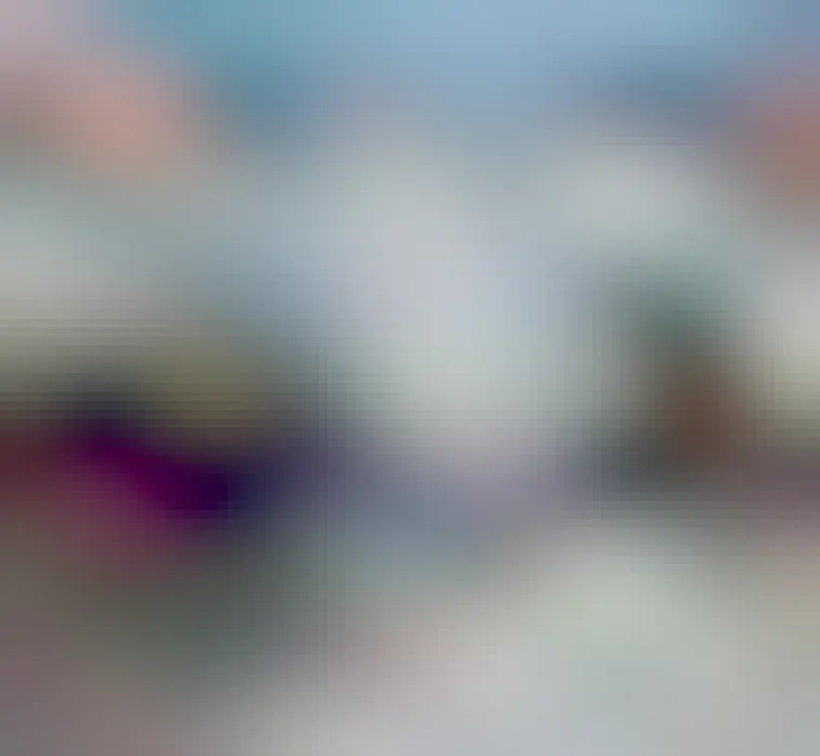 A photo of a small fluffy kitten next to a laptop keyboard 