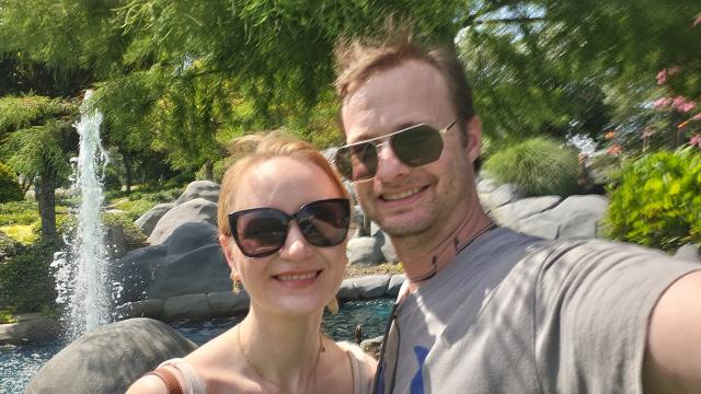 A couple wearing sunglasses at a putt putt course on a sunny day 