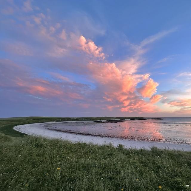 The horseshoe shaped beach at Balranald in North Uist reflects the colours of a glorious sunrise.