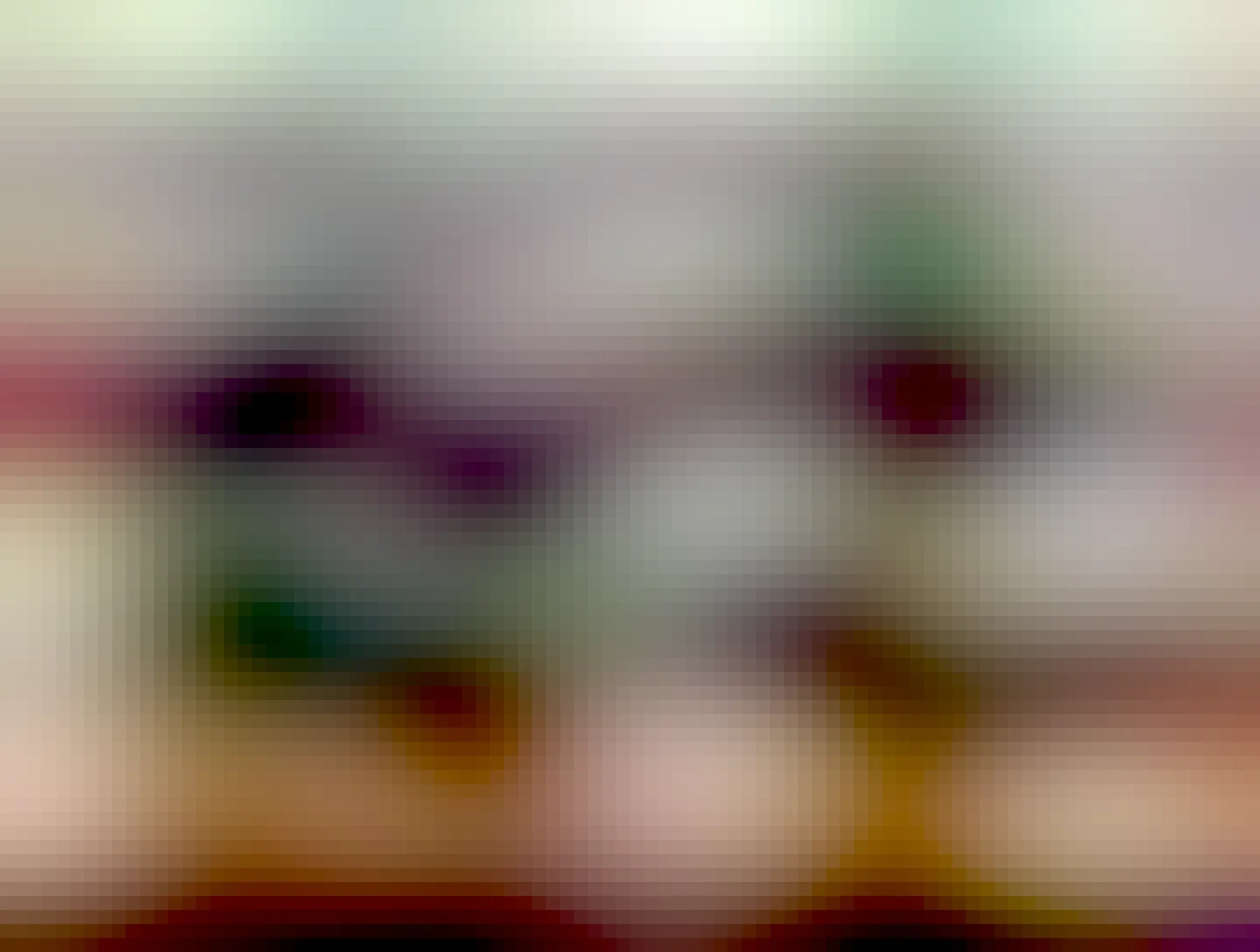 a little gray tabbycat chilling next to a potted plant 