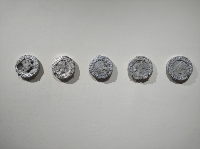 a starting progression of five tokens, from worn and blobby towards crisp and complete.