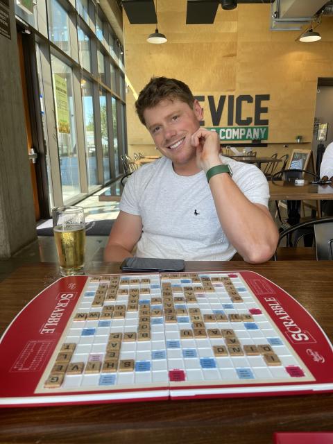 Myself smiling next to a full Scrabble board