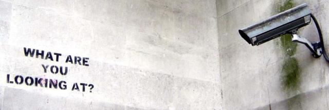 Banksy graffiti: "What Are You Looking At?" in the view of a CCTV camera.