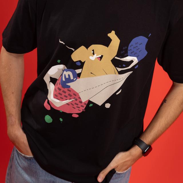 A black t-shirt featuring an elephant riding a paper airplane among different colored planets. The Mastodon logo is visible.