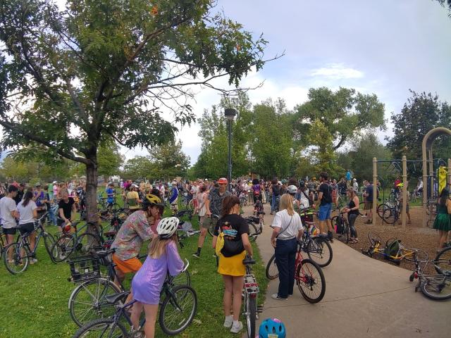 Dozens of people with bikes in a park getting ready for a collective ride