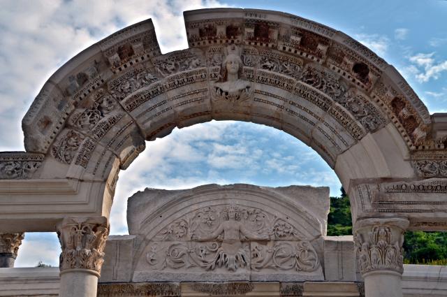 "The archivolt with inscription decorated with the crowning bust of the goddess Tyche, and behind the cella's tympanon of the Temple of Hadrian on Curetes Street, built before 138 AD by the asiarch P. Vedius Antoninus Sabinus, Ephesus, Turkey."

Carole Raddato, CC BY-SA 2.0 via Flickr: https://flic.kr/p/sqkkiS

Color edits.