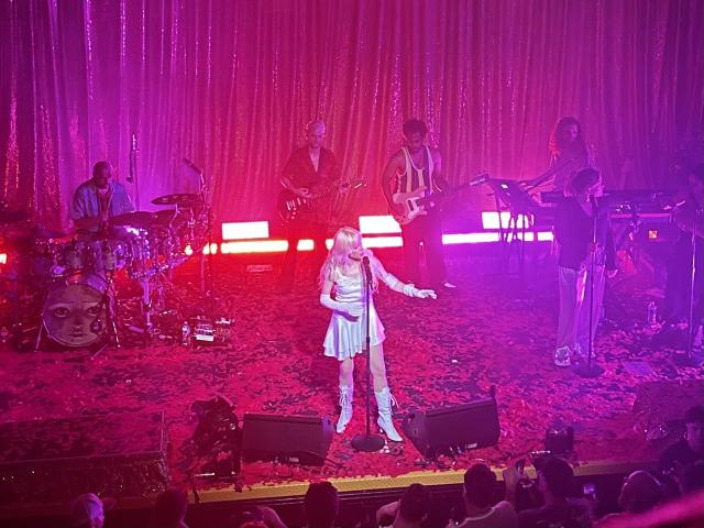 An photo taken from the balcony of Carly Rae Jepsen and her band performing on the stage at Metro Chicago while basked in pink light
