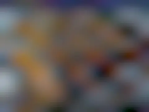 A folded blanket with wide orange and teal stripes. The knitted stitch pattern is very open.