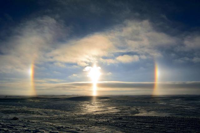 "A sun dog (meteorological name: parhelion), also known as a mock sun, or phantom sun, is an atmospheric phenomenon that typically consists of a bright spot to the left and/or right of the sun."

Rick Bohn / USFWS Mountain-Prairie, CC BY 2.0, via Wikimedia Commons. Color edits.