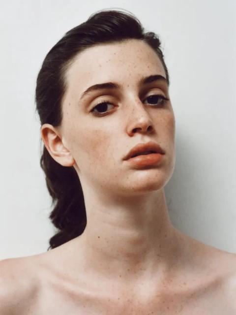 Tight color portrait of a woman looking directly at the camera framed at the collar bone