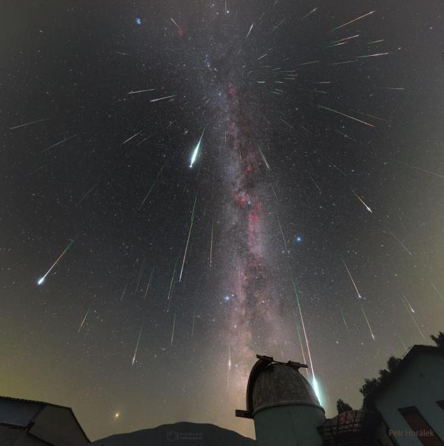 Mulitple streaks cover a night sky filled with stars. An observtory dome is visible in the foreground.