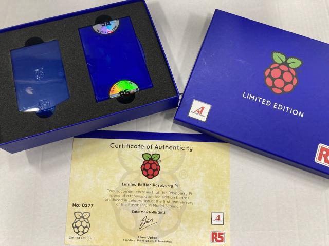 A blue cardboard presentation box containing a limited edition (number 0377/1000) RaspberryPi model B with a certificate of authenticity. The logic board is still in its sealed packet. 