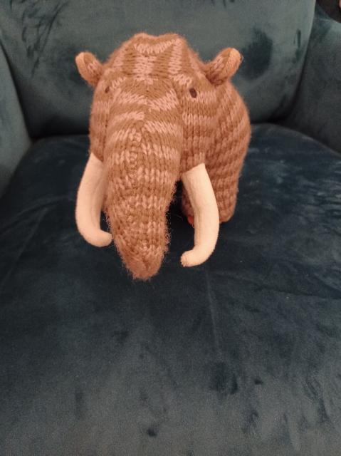 Knitted toy mammoth with brown and beige stripes