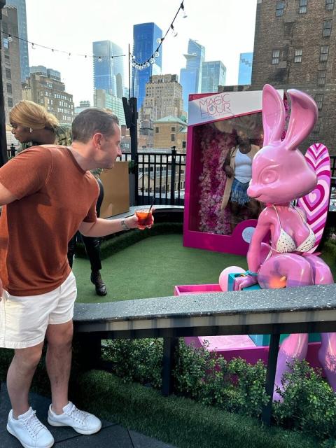 Me, holding a Negroni, talking to a rabbit statue