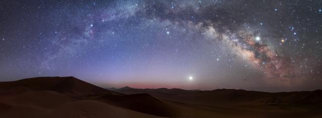 "Second place in the 2021 IAU OAE Astrophotography Contest, category Wide star fields: Milky Way Arch over Lut Desert, Iran, by Amirreza Kamkar, Iran (Islamic Republic of)."

Amirreza Kamkar/IAU OAE, CC BY 4.0, via Wikimedia Commons.