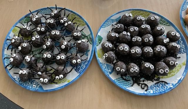 “Urchin” snacks constructed from Dunkin’ chocolate munchkins. On the left plate are “healthy urchins” with licorice spines and candy eyes. On the right plate are dying urchins (munchkins with crossed out eyes, that have lost all their spines) 