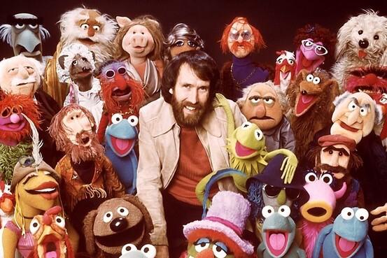 Jim Henson surrounded by many of The Muppets, including Kermit the frog & many others.