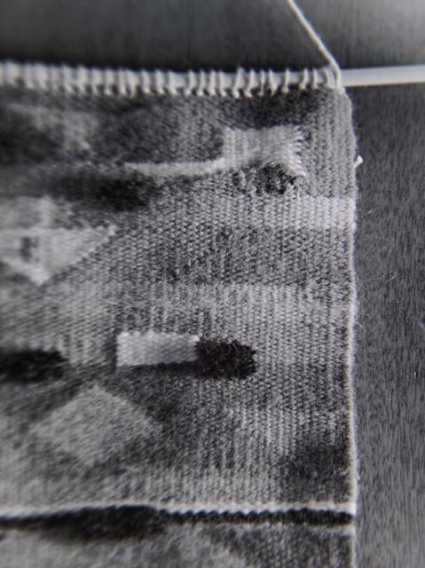 Black and white photo of fiber arts piece hanging. Close up.