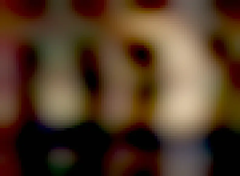 A person is seen standing at the top of a ridge. The person appears as a silhouette onto the central dark region of an annular solar eclipse. The annular solar eclipse is a bright ring with a large dark hole in the middle.