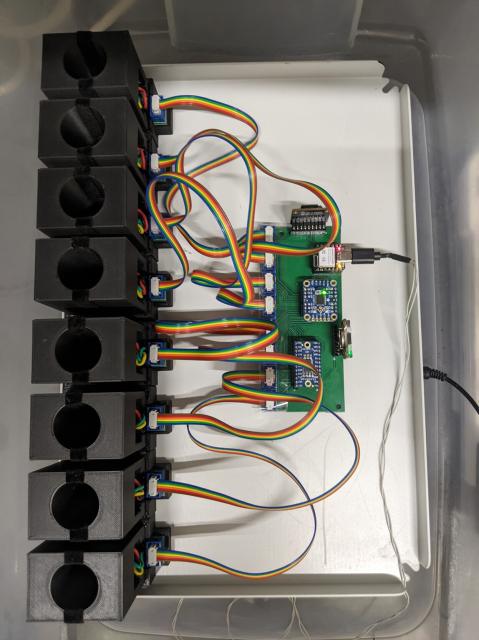 Top down picture of custom OD meter, tube holders on the left, connected by ribbon cables to custom circuit on the right. 