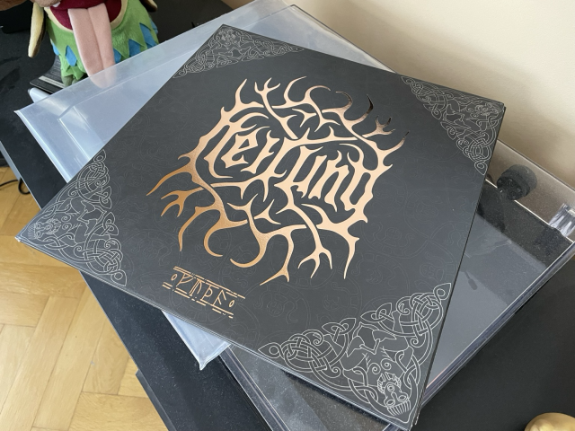The cover of a vinyl record. On a black background, Heilung is embossed in gold. Below, the title of the album (Futha) is spelled using runes. 