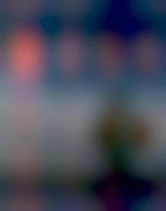 A lone tree is seen on the right of a dark grassy field. Above and on the right, a bright red filamentary glow is seen in the sky. The filaments of this glow may seem similar to the branches of the tree.