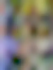 The author standing at an outdoor pottery wheel, helping a kid throw a pot for the first time.